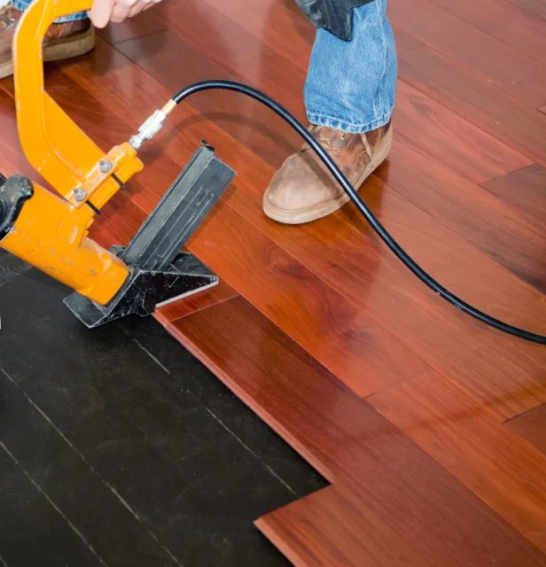 Flooring nailer driving a cherry hardwood board
