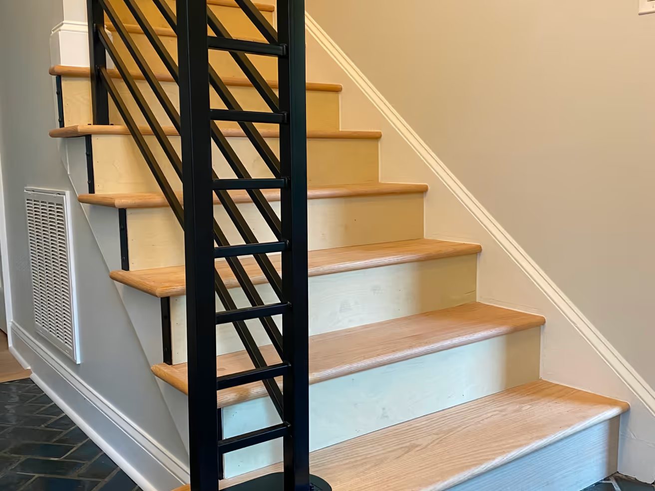 Floating staircase with black steel stringers and light wood treads